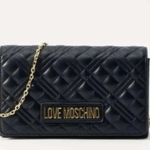 Svart quiltad axelväska Love Moschino - Stilren svart axelväska från Love Moschino med quiltad design och guldfärgad kedja. Väskan har ett stort Love Moschino-emblem framtill och magnetlås. Tillverkad i skinnimitation. Väldigt bra skick, äkta märke💕.