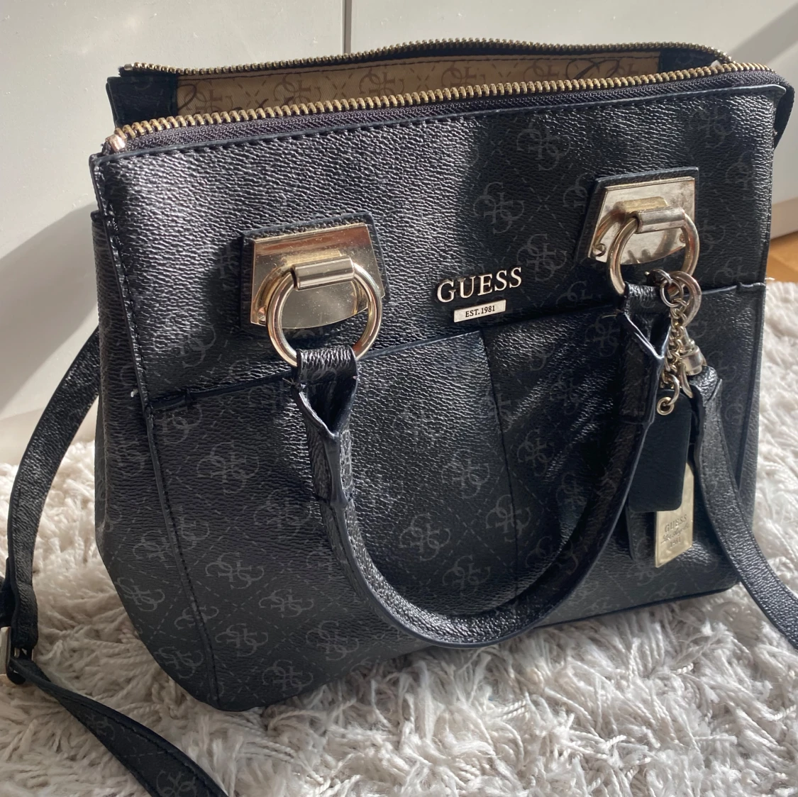 Svart handväska från Guess med gulddetaljer