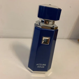 Azzure Aoud parfym French Avenue - Snygg parfymflaska från French Avenue, modellen Azzure Aoud. Flaskan är åttakantig i metallicblått med silvriga detaljer och en blå sten på framsidan. Korken är stor och matchar flaskans design. Perfekt för dig som gillar exklusiva och unika dofter. Inte använt den så mycket ca 90 ml kvar