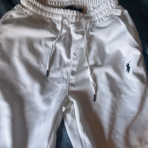 Vita shorts från Polo Ralph Lauren - Fräscha vita shorts från Polo Ralph Lauren med elastisk midja och snörning. Klassisk design med broderad logga på benet och mjukt material som känns skönt mot huden. Perfekta för chill dagar och sommarhäng, stilrena och enkla att matcha med din favorit-t-shirt.