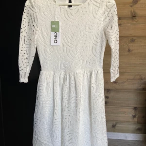 Vit spetsklänning från ONLY XS - Klänningen har rund halsringning och är fodrad undertill. Ny med prislapp