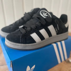Adidas Campus - Säljer  ett par stilrena adidas campus 00s i färgerna svart och grå, dessa är knappt använda och i storlek 42, hör gärna av dig vid frågor/intresse