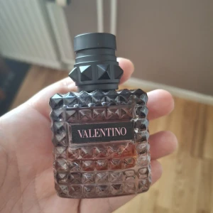 Valentino Eau de Parfum Intense 30ml - Snygg parfym från Valentino, Eau de Parfum Intense, 30 ml. Flaskan är fyrkantig med nitar och mönstrad glasdesign i mörkgrått och svart. Svart etikett med rosa text. Lyxig och edgy look, perfekt för dig som gillar statement-detaljer.