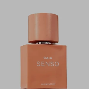 CAIA SENSO Eau de Parfum - Parfymflaska från CAIA i modellen SENSO. Flaskan är fyrkantig och har en matt, persikofärgad finish med matchande rund kork. Modern och stilren design som sticker ut på parfymhyllan.