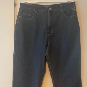 *NY*Tasty blå jeans med smal fotvidd 34/32 (L) fr Jensens kläder  - Mörkblå kvalitetsjeans från Tasty med smal fotvidd och klassisk femficksdesign. Snygga kontrastsömmar och dekorativ söm på bakfickorna. Stretchigt material för extra komfort. Perfekta för dig som gillar en stilren och enkel look. Uppskattar att de passar bäst på en stl L, 42 upptill. Nypris: 599 sek, Pris nu: 100 sek 