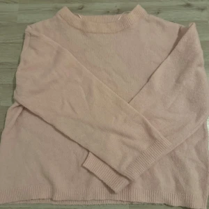 Ljusrosa stickad tröja från 157 - Mysig ljusrosa stickad tröja från 157 med rund halsringning och ribbade muddar vid ärmslut och nederkant. Perfekt för lager-på-lager och enkel att matcha med jeans eller kjol. Långärmad och i en skön, lite loose passform.