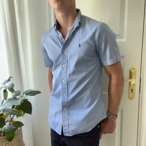 Polo Ralph Lauren skjorta ljusblå randig - Randig RL skjorta. Inga defekter. Modellen är 180,75 kg och bär S custom fit 