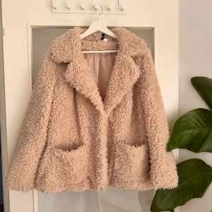 Beige teddyjacka med stora fickor - Supermysig beige teddyjacka med stora fickor och bred krage från hm. Använd sparsamt och är i väldigt bra skick.