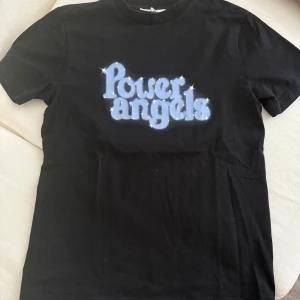 Svart Power Angels t-shirt från Ganni - Cool svart t-shirt från Ganni. I väldigt fint skick.