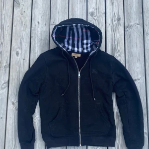 Svart burberry hoodie M - Burberry hoodie i bra kvalité, samma som min andra hoodie har den lite katthår på sig men det tar jag bort såklart innan jag skickar, men bilderna har fortfarande det på för jag stressade när jag tog dem. Men kan gärna skicka bilder med tröjan på med/eller utan katthår på.