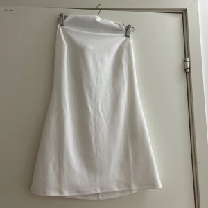 Vit kort klänning från Bik Bok - Supersnygg vit kort klänning från Bik Bok med öppen rygg och knyt i nacken. Klänningen har en enkel, stilren design och är tillverkad i ett mjukt material som känns skönt mot huden. 