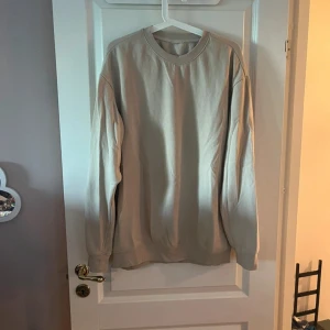 Beige sweatshirt i bomull - Enkel och stilren beige sweatshirt med rund hals och långa ärmar. Tröjan är i mjuk bomull och har en relaxed passform, perfekt för en chill och avslappnad look.