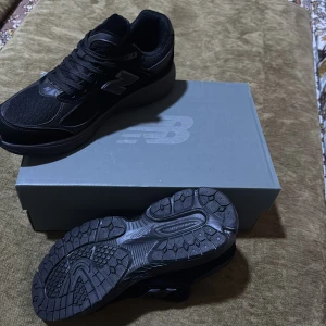 New Balance 2002R svarta sneakers - Svarta New Balance 2002R sneakers med mesh och mockadetaljer, silvergrå logga och detaljer på sidorna. Snygg chunky sula med bra grepp och klassisk snörning. Perfekta för dig som gillar streetwear och sportig stil. PRIS KAN DISKUTERAS ALDRIG ANVÄNTS ALDRIG