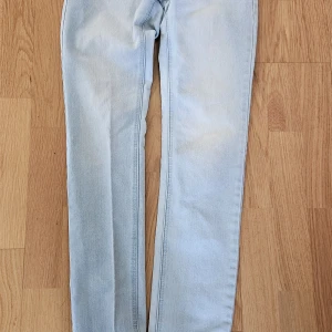 Ljusblå jeans från Gina Tricot, stl 28 - Snygga ljusblå jeans från Gina Tricot i klassisk femficksmodell. Jeansen har en slim passform och raka ben, tillverkade i mjukt bomullsjeans. Perfekta för dig som gillar en enkel och fräsch look.