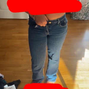 Blå jeans från Vero Moda - Snygga blå jeans från Vero Moda med klassisk femficksmodell och raka uppe men breda där nere. Jeansen har normal midja och är tillverkade i mjukt denimtyg som sitter skönt. Perfekta till sneakers eller boots för en chill look. Längst nere vid benen så är färgen lite borta men de är inget som syns eftersom att de är vid fötterna.