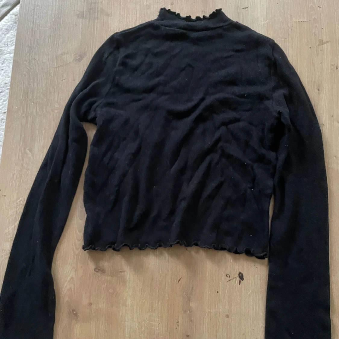 Svart finstickad polotröja med volangkant