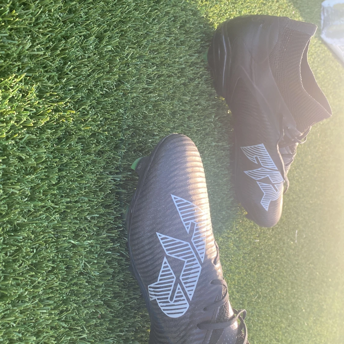 Svarta fotbollsskor med vit logga