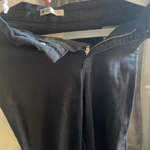 Svarta byxor från Gina Tricot XS - Svarta byxor från Gina Tricot i storlek XS. Klassisk femficksmodell med dragkedja och knapp framtill. Byxorna har raka ben och är tillverkade i ett mjukt bomullsmaterial. Perfekta till en chill vardagslook.