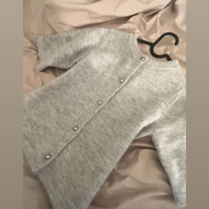 Ljusgrå stickad kofta med pärlknappar - Söt kofta/tröja från Gina tricot. Aldrig använt 