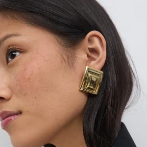 Stora fyrkantiga örhängen i guld - Säljer ett par chunky fyrkantiga örhängen i guldmetall med cool 3D-effekt. De har en retrovibe och är perfekta för att sticka ut. Snygga till både basic och mer dressade outfits. Lätta att bära och ger en statement-look. Säljer två st då de aldrig användes🥰