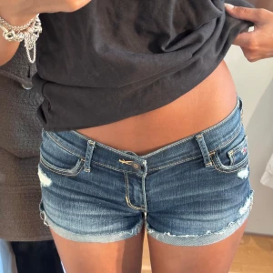 hollister low rise  - Snygga lågmidjade jeansshorts i klassisk blå denim med slitna detaljer och råa kanter. 