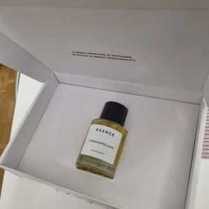 ESSNCE Carashmellow Eau de Parfum - Parfymen Carashmellow från ESSNCE kommer i en stilren, rund glasflaska med svart lock. Vätskan är gyllengul och etiketten är vit med minimalistisk svart text. . Perfekt för dig som gillar unika dofter och snygg design. Den är oanvänd. 