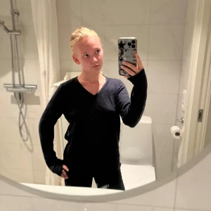 Mörkblå stickad v-ringad tröja - Mysig mörkblå stickad tröja med v-ringning och långa ärmar. Perfekt för lager-på-lager och enkel att matcha med både jeans och kjol. Snygg och stilren modell som passar till många olika looks.