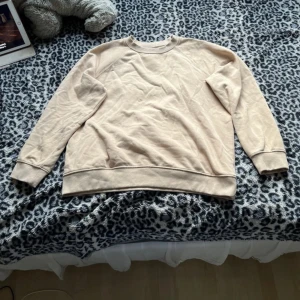 Beige sweatshirt i bomull - Enkel och stilren beige sweatshirt med rund halsringning och långa ärmar. Tröjan har ribbade muddar vid ärmslut och nederkant. Perfekt för en chill och avslappnad look. Tillverkad i mjuk bomull för extra komfort.