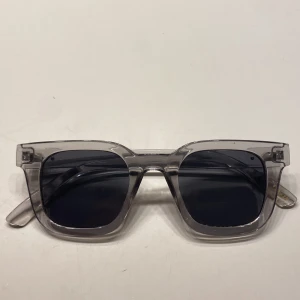 Transparenta solglasögon från Glitter - Snygga solglasögon från Glitter med transparent, fyrkantig båge i plast och mörka glas. Perfekta till sommaren!!!🤩