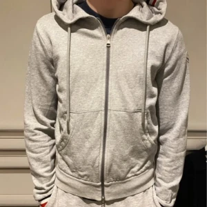 Moncler Hoodie - Grå moncler hoodie i storlek M. 9/10 skick, qr-kod funkar. Nypris ca. 4500. Mitt pris 1599kr.