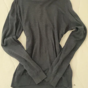 Mörkgrå merinoulltröja John Smedley - Snygg mörkgrå långärmad tröja från John Smedley i mjuk merinoull. Klassisk rund halsringning och smal passform som sitter riktigt bra. Perfekt för dig som gillar stilrena och tidlösa plagg med premiumkänsla.