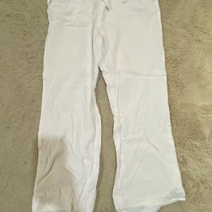 Vita linnebyxor från 157, XS - Snygga och luftiga vita linnebyxor från 157 i storlek XS. Byxorna har rak passform, resår i midjan och är perfekta för varma dagar. Stilen är enkel och fräsch, passar till allt och ger en chill vibe. Byxorna är insydda vid slutet av benen då dem var lite för långa för mig men passar alla som är från 150-160. Använt dem en gång och är nya 