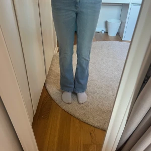 Ljusblå bootcut jeans - Säljer ett par ljusblå jeans med bootcut-modell och klassisk femficksdesign. Jeansen har en medel midja och är tillverkade i mjukt denimtyg som ger en skön passform.