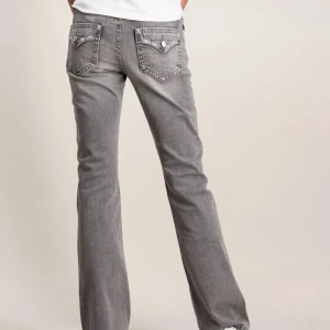 Grå bootcut jeans med detaljer - Ett par jättesnygga modernt lågmidjade grå jeans från Gina tricot! Jag hittade inte bild på exakt de jag har  men de ser typ exakt likadana ut bara att det inte är något glitter på bakfickan utan det är bara broddererat (nypris:399)