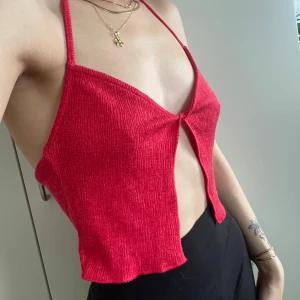 Röd croppad halterneck linnetopp - Säljer en röd croppad linnetopp med halterneck och öppen rygg.