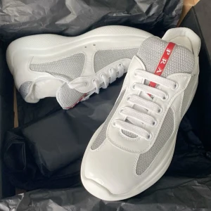Prada skor  - Säljer ett par snygga och stilrena vita American Prada Cup-sneakers i storlek 41 – lyxiga, bekväma och perfekta för en vardagslook med exklusiv känsla.  Skolåda ingår, skick 10/10. Pris kan diskuteras vid snabb affär! 