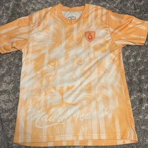 Galatasaray Icardi 99 fotbollströja - Snygg kortärmad Galatasaray fotbollströja från Nike i gul och vit med lejonmotiv på framsidan och Icardi 99 på ryggen. Tröjan har klubbmärke på bröstet och är tillverkad i Dri-Fit material för bra komfort.