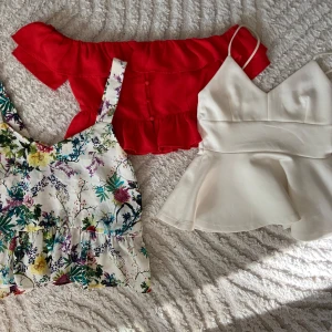 Paket:  3 Toppar - 3 Toppar alla i bra skick utan några skavanker.  Den röda toppen är en off shoulder bardot topp. Den är i storlek 34 och har knappar samt volanger vid bröstkorgen. Märket är Fashion Union. Den vita toppen är från Gina Tricot i storlek S. Smala band och volang nedtill. Den blommiga toppen svänger ut nedtill och är från stradivarius i storlek S.