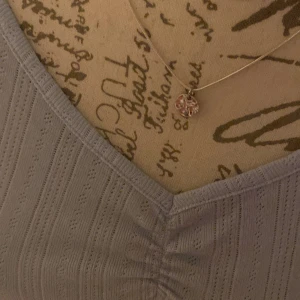 Ljusblå ribbad topp med v-ringning - Söt ljusblå topp med korta ärmar och v-ringning. Toppen har ribbat mönster och rynkade detaljer framtill. Perfekt för en avslappnad och trendig look.