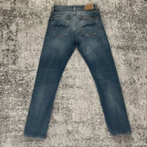 Blå jeans från Nudie Jeans - Snygga blå jeans från Nudie Jeans med klassisk femficksdesign. Jeansen har en rak passform. Jeansen är i fint skick och är inte använda mycket. Ny pris 1600, vårat 450