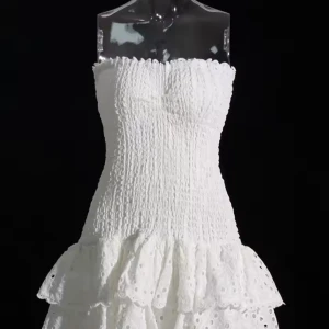 Vit axelbandslös klänning med volang - Säljer en söt vit axelbandslös klänning med smockad överdel och dubbla volanger nertill. Klänningen har broderade detaljer och är perfekt för sommarens alla tillfällen. Lätt och luftig modell som ger en romantisk känsla.