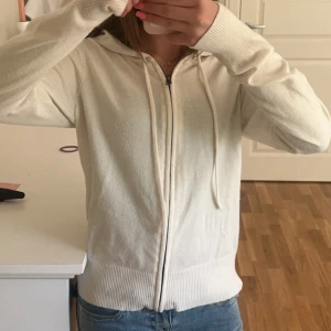 Beige hoodie med dragkedja - Säljer en krämvit hoodie med dragkedja och huva. Tröjan har långa ärmar, ribbade muddar och dragsko vid huvan. Perfekt för en avslappnad stil. Har använt den ett fåtal gånger! Pris kan diskuteras!💘