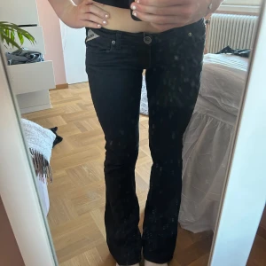 Svarta lågmidjade jeans - Svarta jeans från Replay med bootcut-passform och klassiska fem fickor. Byxorna har låg midja och diskreta sömdetaljer på bakfickorna. Perfekta för en stilren och enkel look. Lite slitna vid botten av byxan (se sista bild)