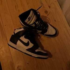 Nike Dunk High svartvita sneakers - Säljer ett par klassiska Nike Dunk High sneakers i svart och vitt. 