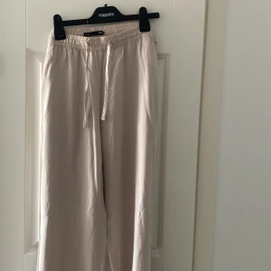 Beige Linnebyxor - Säljer ett par beige linnebyxor i storlek M som är helt oanvända. 