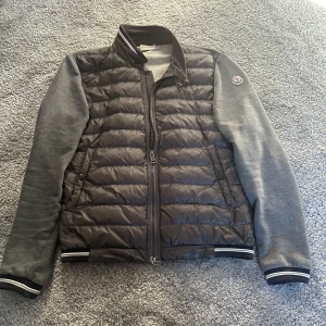 Grå Moncler Cardigan - Säljer nu denna extremt feta gråa moncler cardiganen. Passar perfekt nu till de varmare tiderna men kan även användas till sen höst. Den är storlek S och har inga skador eller fläckar.  Den passar även XS. Skicket är 8,5/10. Dm för frågor!