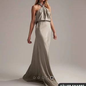 Champagnefärgad långklänning med halterneck - Supersnygg långklänning i champagnefärgat satin med halterneck och draperad överdel. Klänningeb är helt oanvänd från Asos❤️