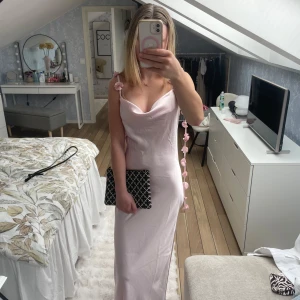 Ljusrosa långklänning med blommiga axelband🩷 - Säljer min ljusrosa långklänning med smala axelband dekorerade med små blommor.🌸Klänningen har en cowlneck-ringning och är figurnära med slät, glansig yta. Perfekt för bal eller speciella tillfällen! Tyvärr har ena bandet nästan gått av(va så när ja köpte den) men jag har sytt fast det så det är inget man tänker på eller märker av.🥰nypris 700kr