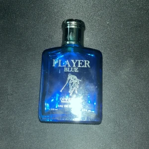 Player Blue Eau de Toilette från Giverny - Pris kan diskuteras                                        Fräsch herrparfym i en stilren blå glasflaska med silverfärgad kork. Doften heter Player Blue och flaskan rymmer 100 ml. Perfekt för dig som gillar sportiga och maskulina dofter.