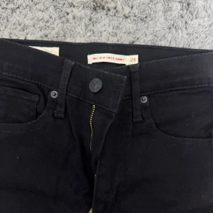 Svarta high waist skinny jeans från Levi's - Säljer ett par svarta high waist skinny jeans från Levi's. Modellen är super skinny med klassisk femficksdesign och dragkedja. Perfekta svarta jeans som sitter tight hela vägen ner. Köptes för 1200kr och användts ett par gånger bara
